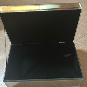 A jewelry box with that is mirror based with a glittery based top